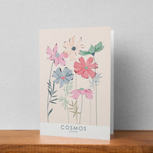 Load image into Gallery viewer, A greeting card featuring a cosmos illustration stood up against a pale background. The text on the illustration reads cosmos cosmos
