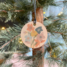 Load image into Gallery viewer, Decorative wooden tag with floral design hanging on a Christmas tree.

